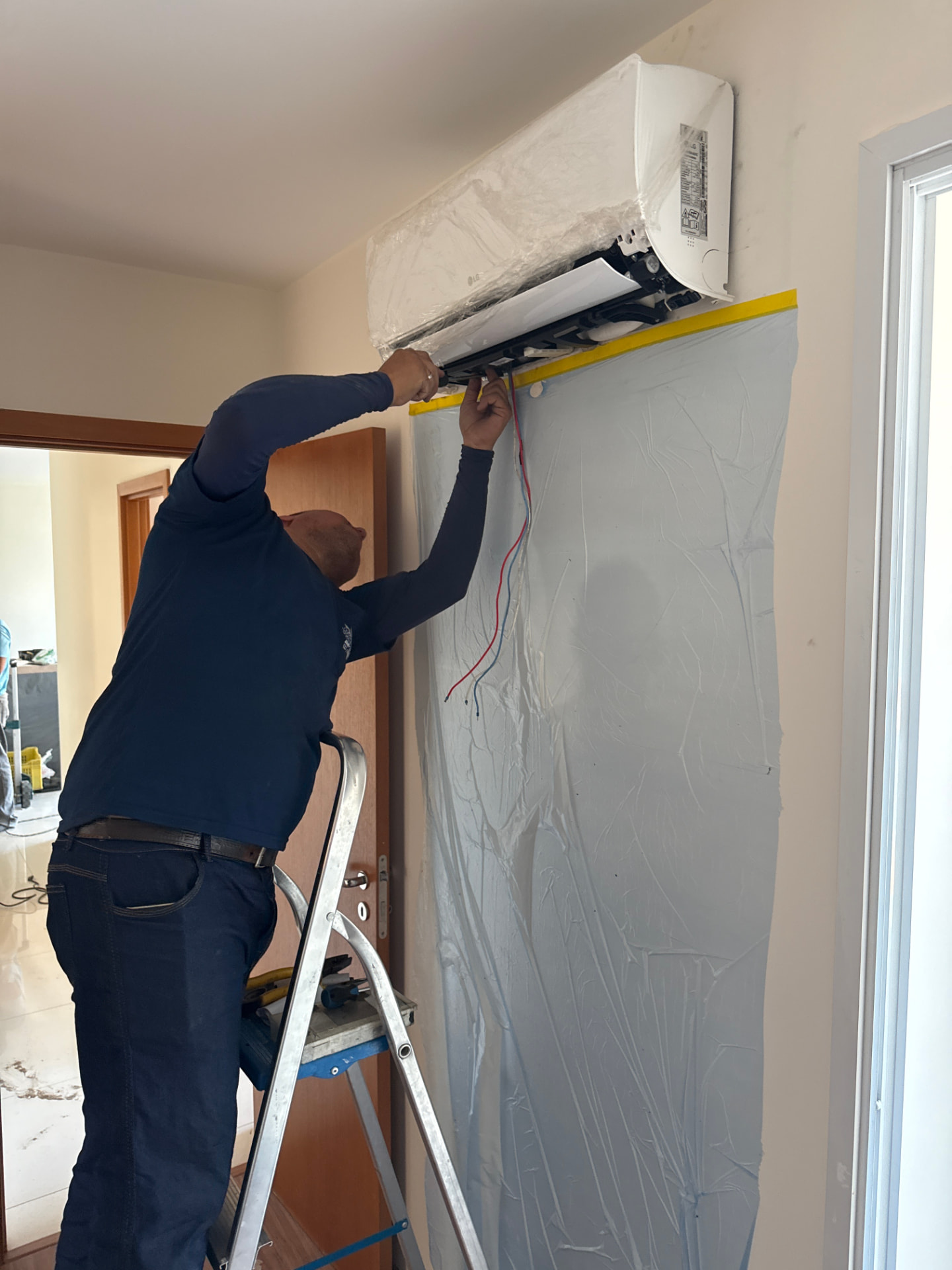 Técnico da Isotec instalando unidade de ar-condicionado em ambiente residencial